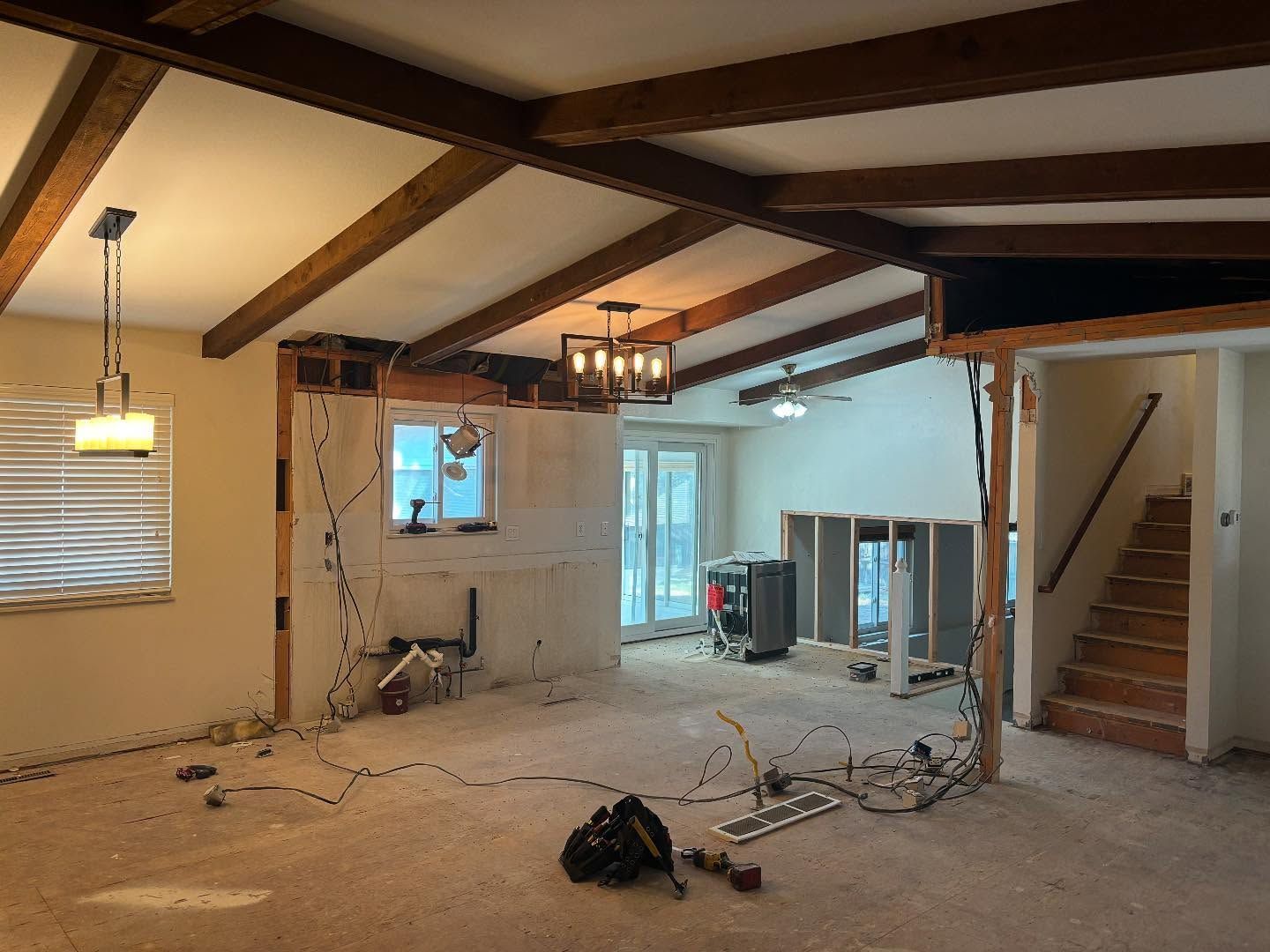 Interior renovation, walls partially removed. Exposed beams, wiring, and unfinished surfaces.