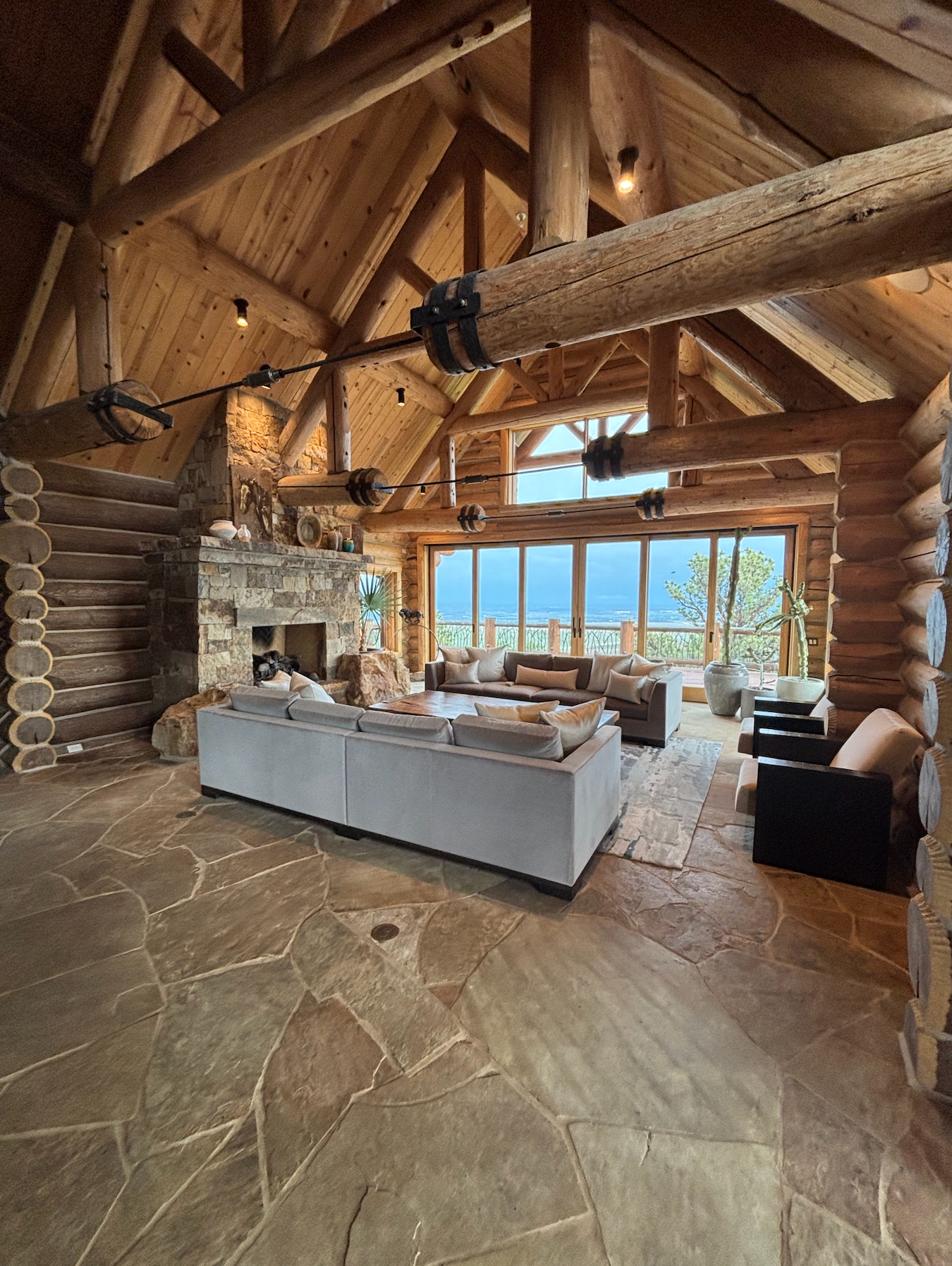 Modern kitchen with white island, pendant lights, and open to living space with large windows.