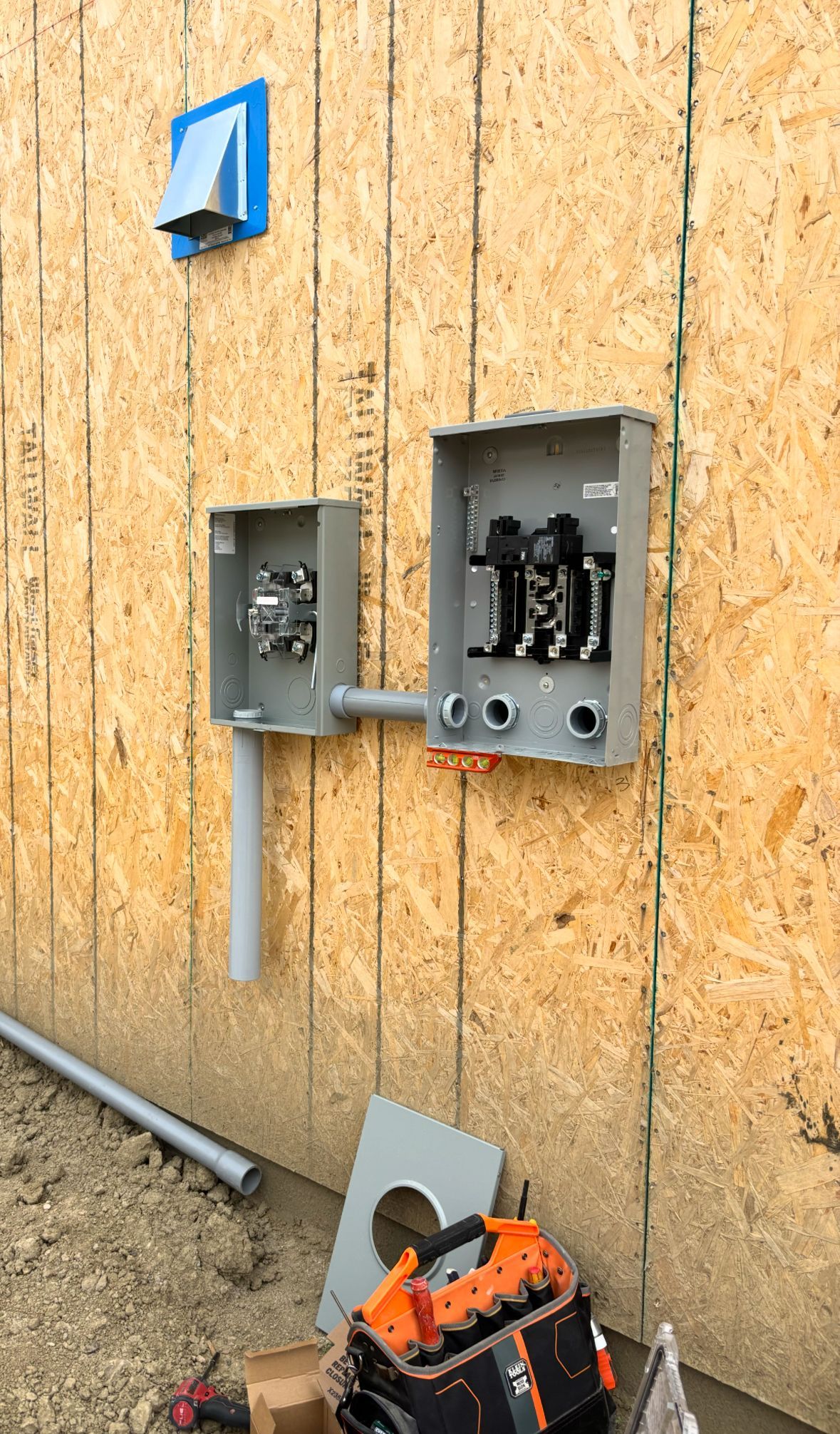 Interior undergoing renovation: exposed beams, wires, framing, and stairs.