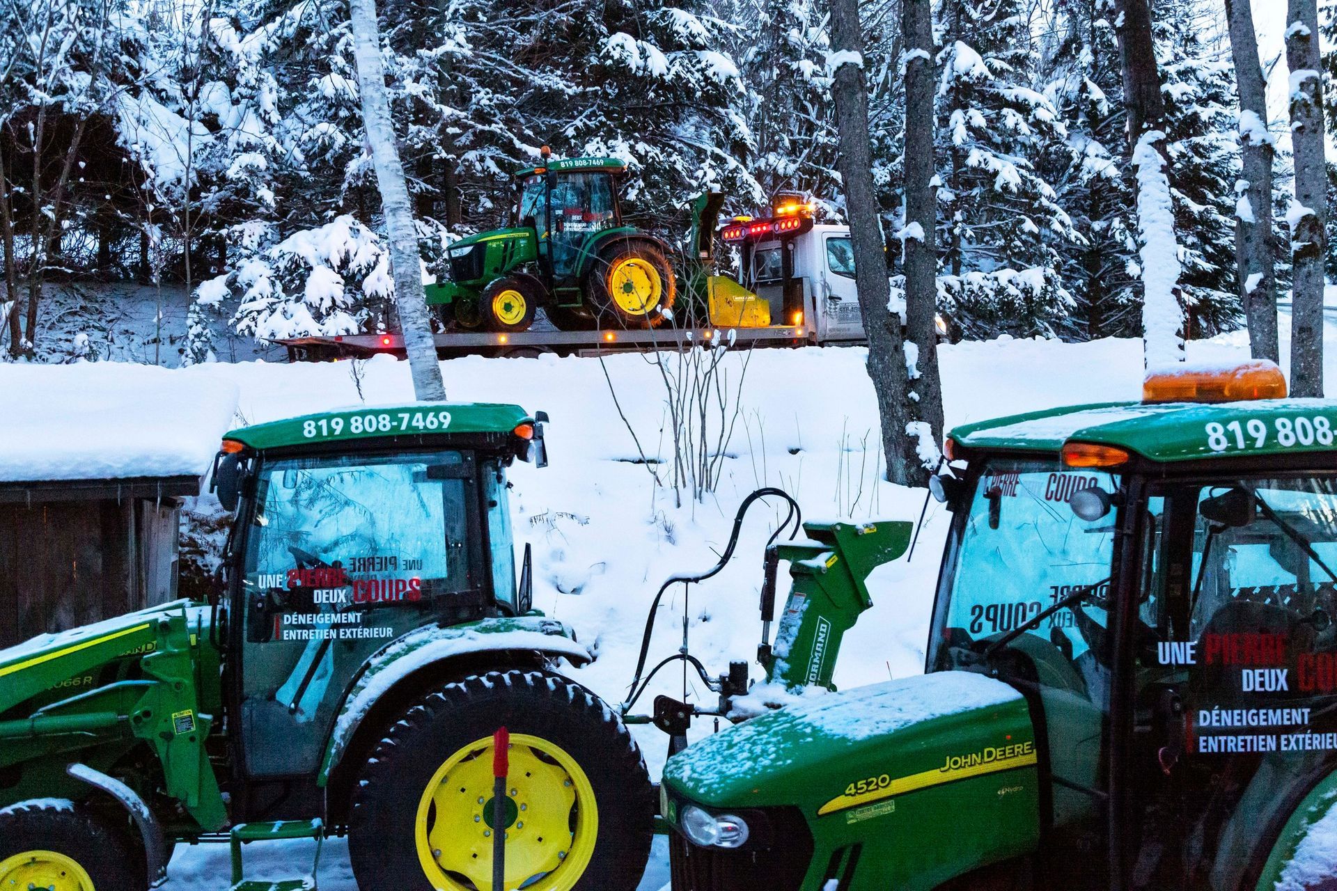 Deux tracteurs John Deere sont garés dans la neige