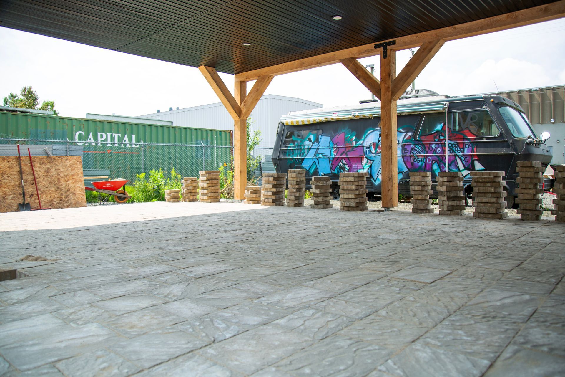 Une camionnette avec des graffitis sur le côté est garée sous un auvent.