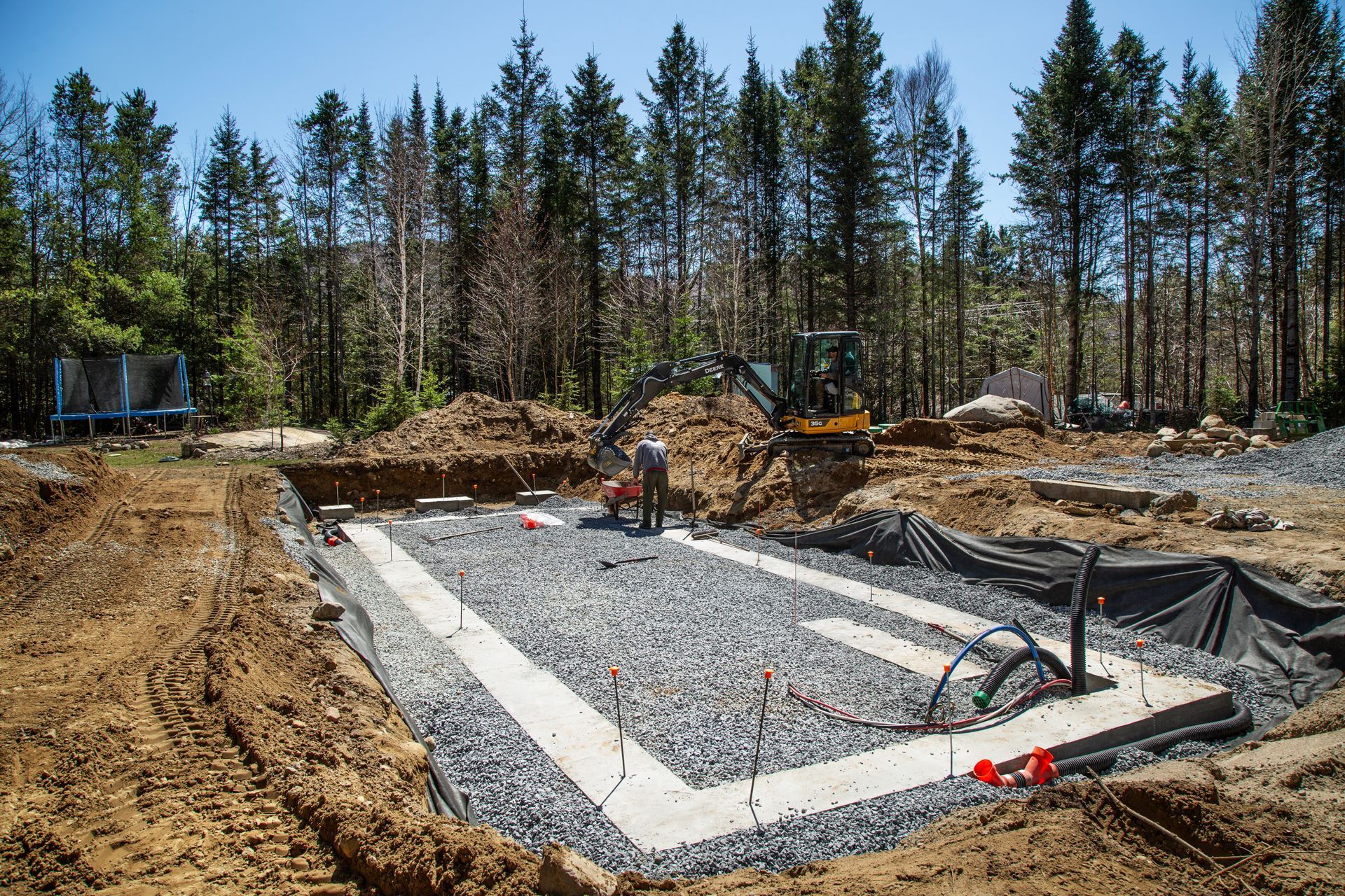 Un chantier avec beaucoup de terre et d'arbres en arrière-plan.