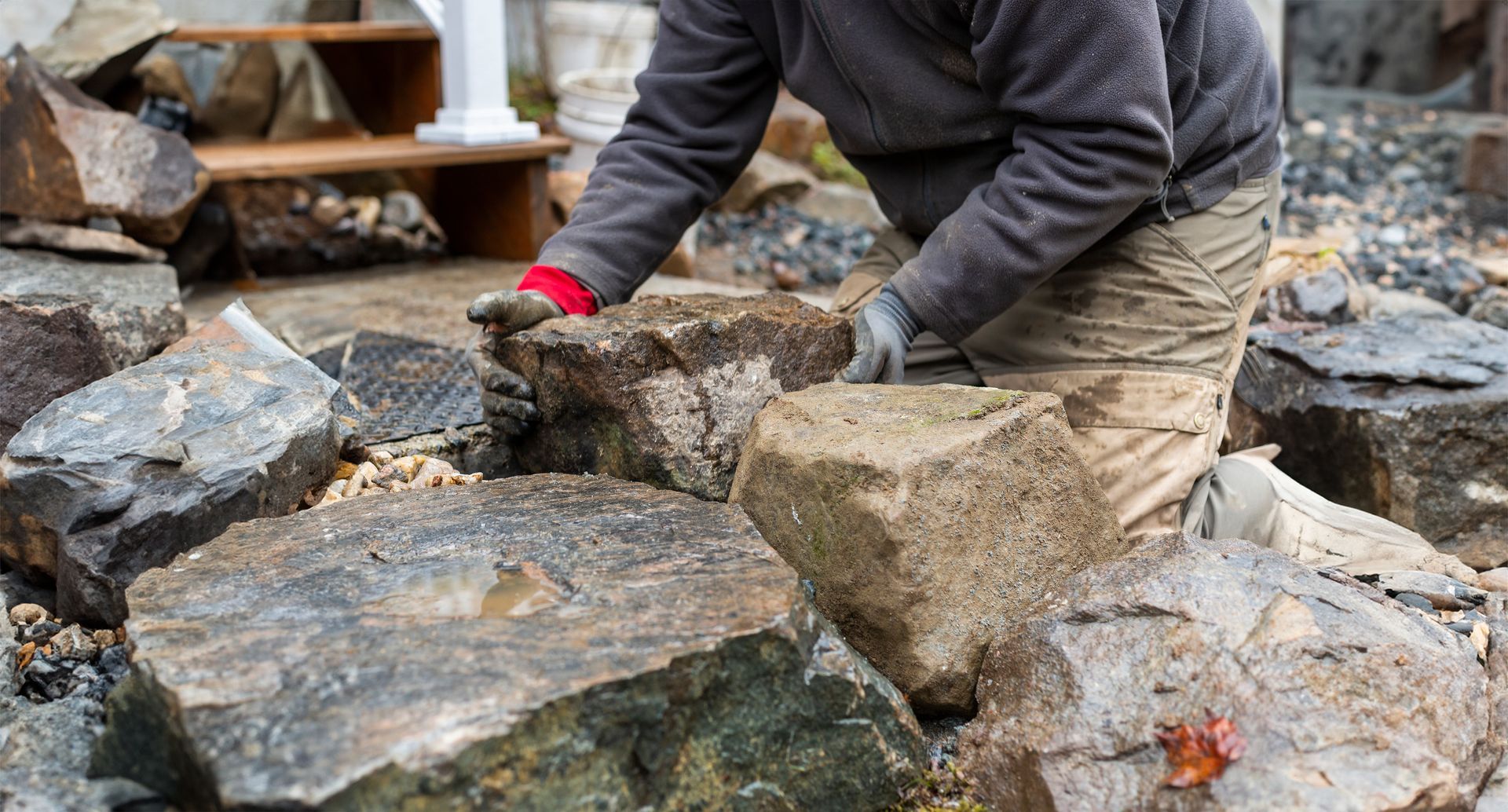 Un homme est à genoux devant un tas de rochers.