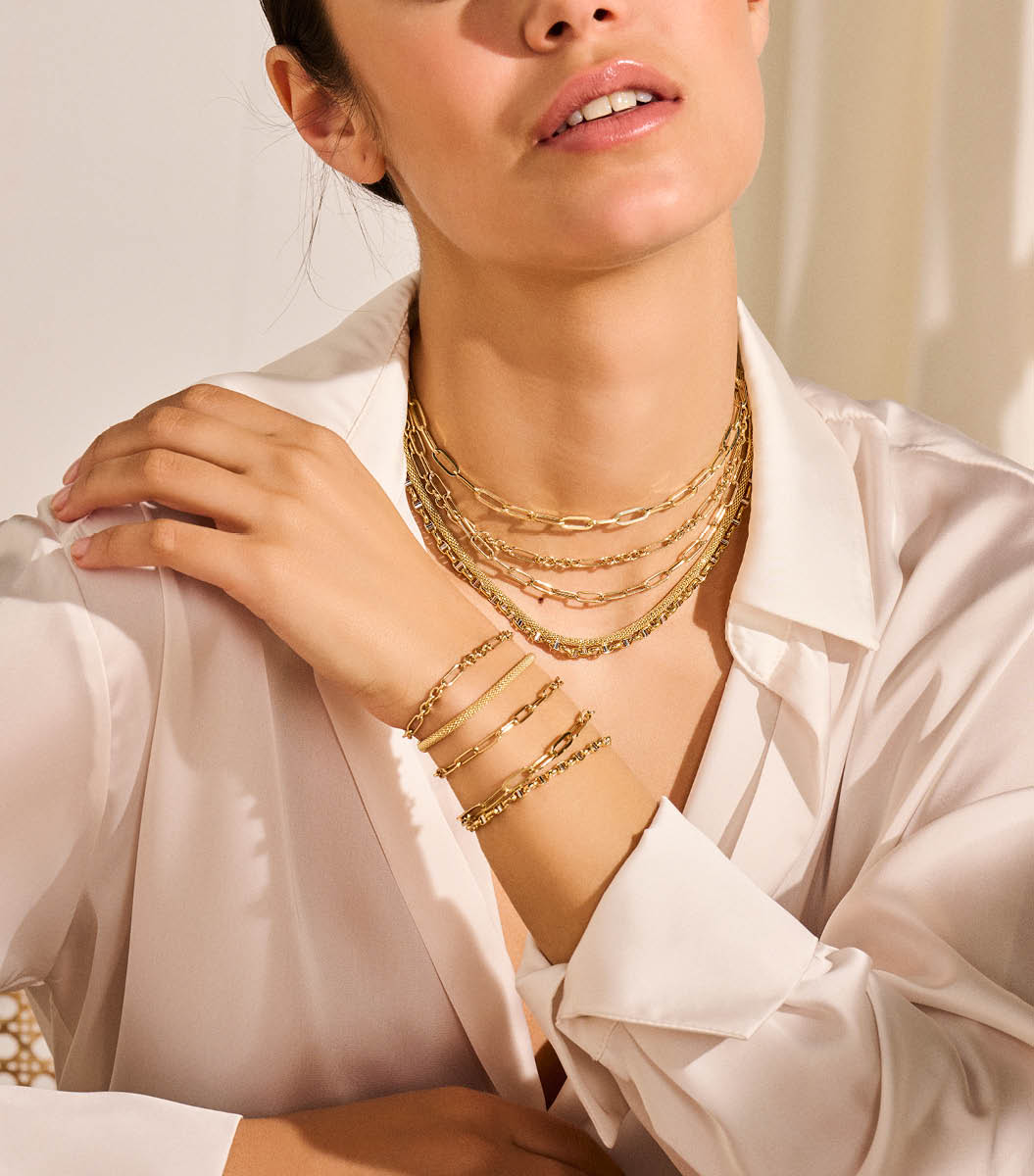 Een vrouw in een wit overhemd en gouden sieraden