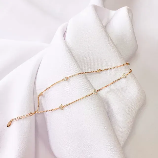 Een gouden ketting ligt op een witte doek.