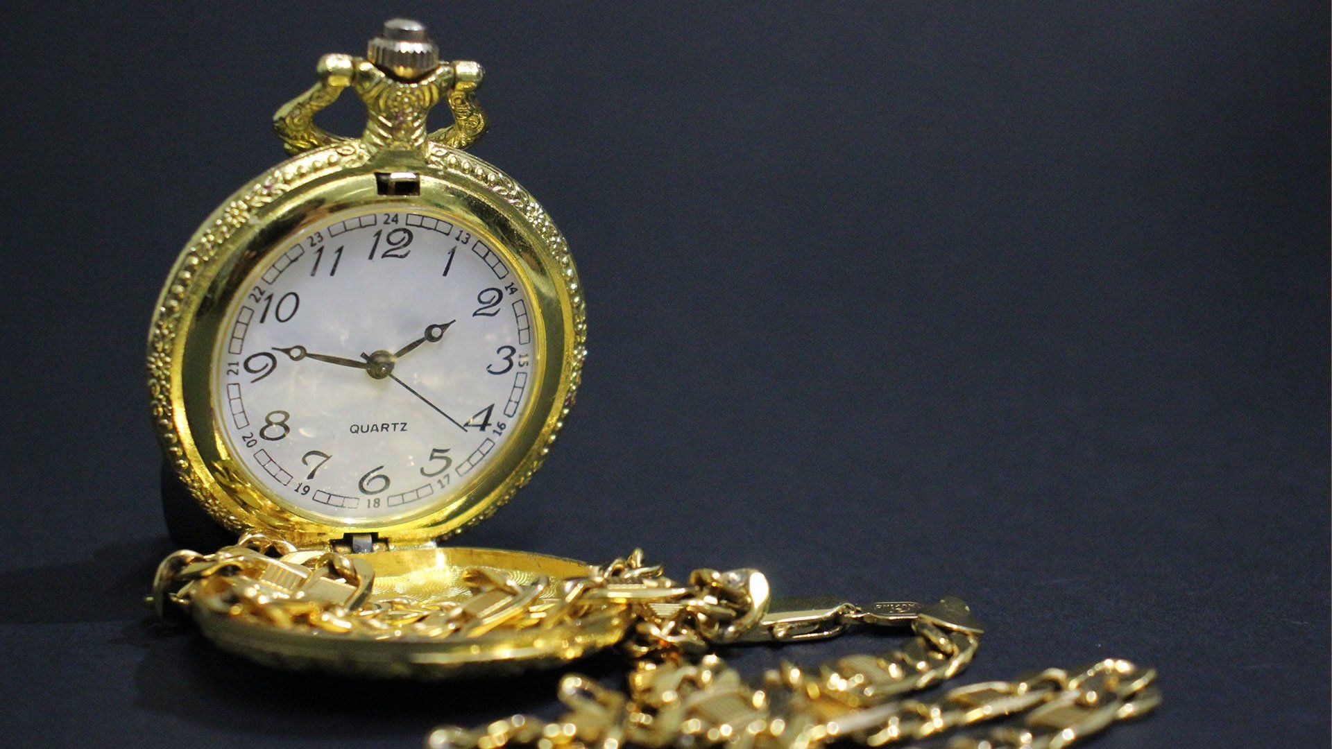 Een close-up van een gouden zakhorloge aan een ketting