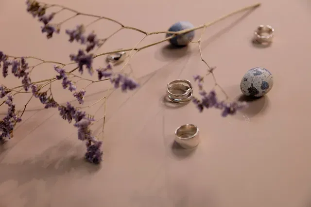 Een bosje ringen en bloemen op een tafel.