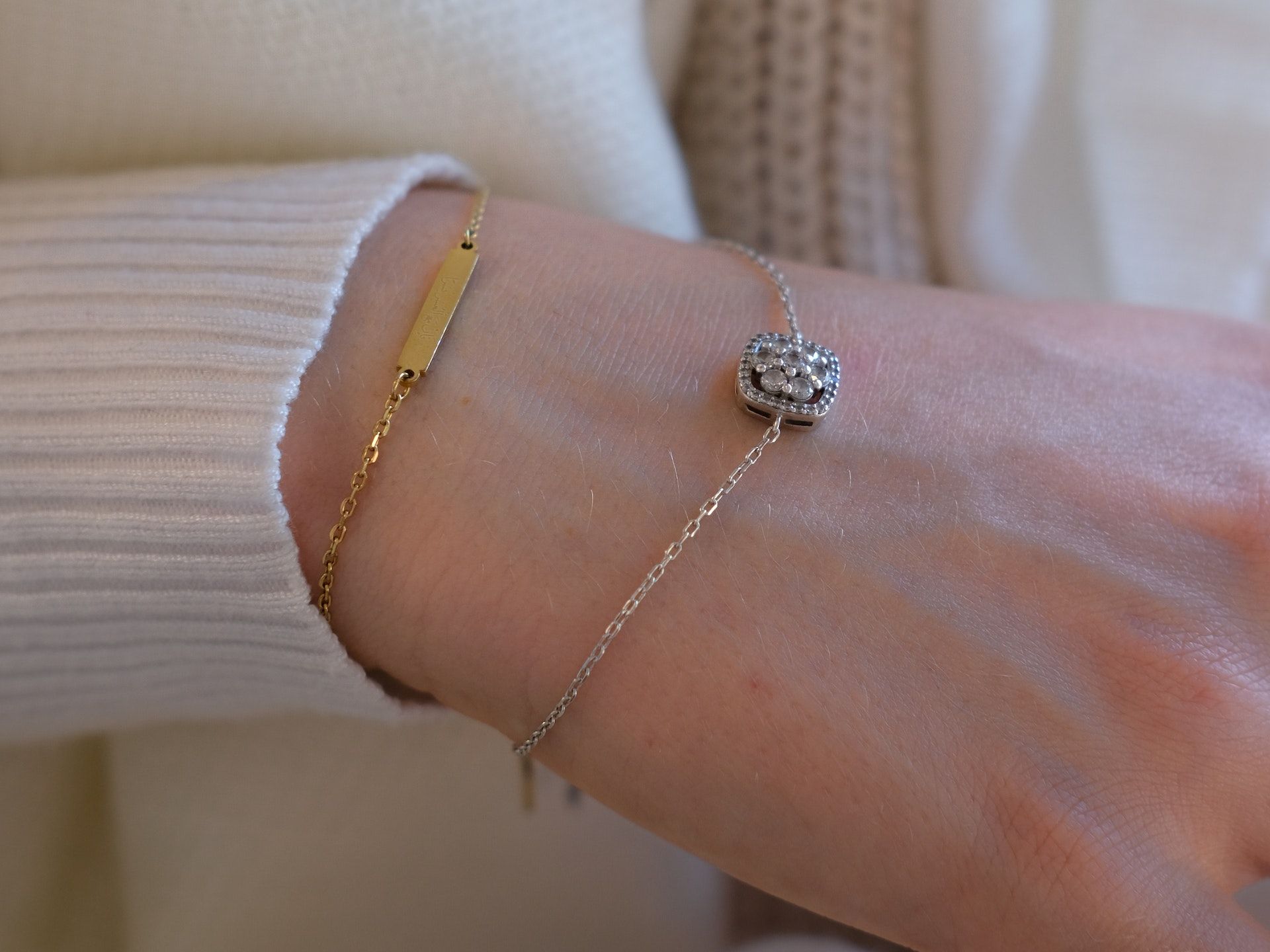 Een vrouw draagt twee armbanden om haar pols.
