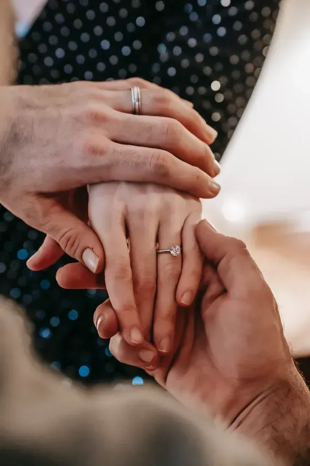 Een man schuift een verlovingsring om de vinger van een vrouw.