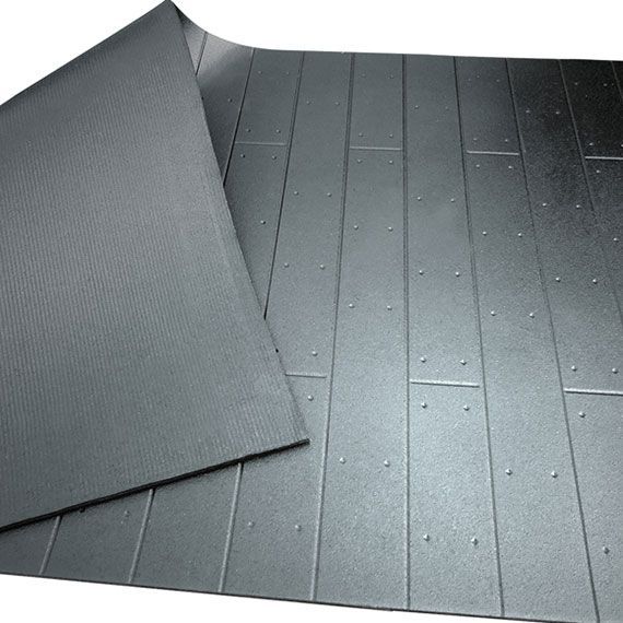 Tapis de sol en caoutchouc gris avec motif de planches de bois texturées partiellement soulevées pour montrer un dessous nervuré.