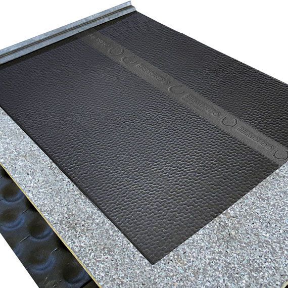 Sous-couche de toiture noire avec bordure grise, recouvrant partiellement une surface grise texturée, prise en biais.