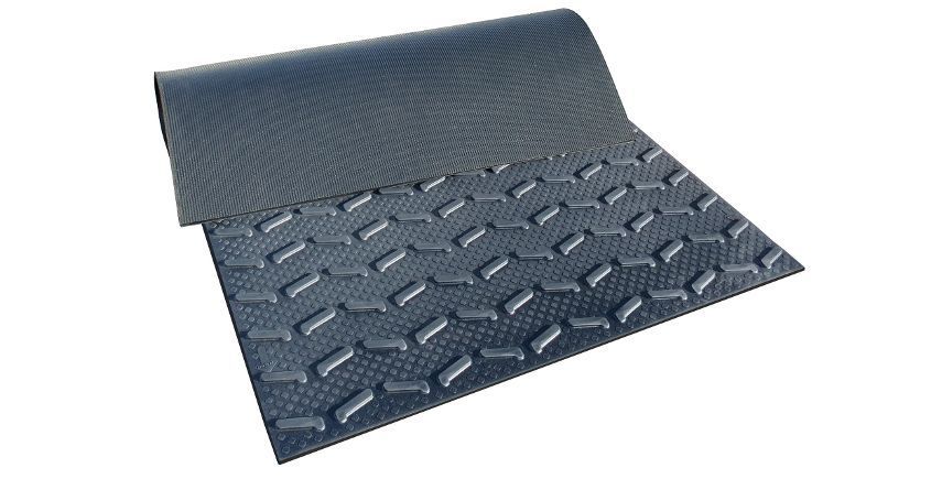 Tapis en caoutchouc gris foncé avec motif losange. Le tapis est enroulé à l'arrière.