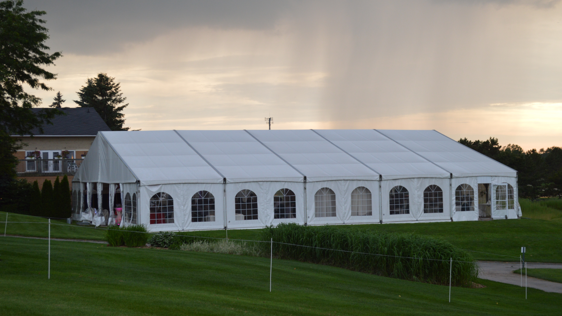 A large black inflatable tent is sitting on top of a lush green field.