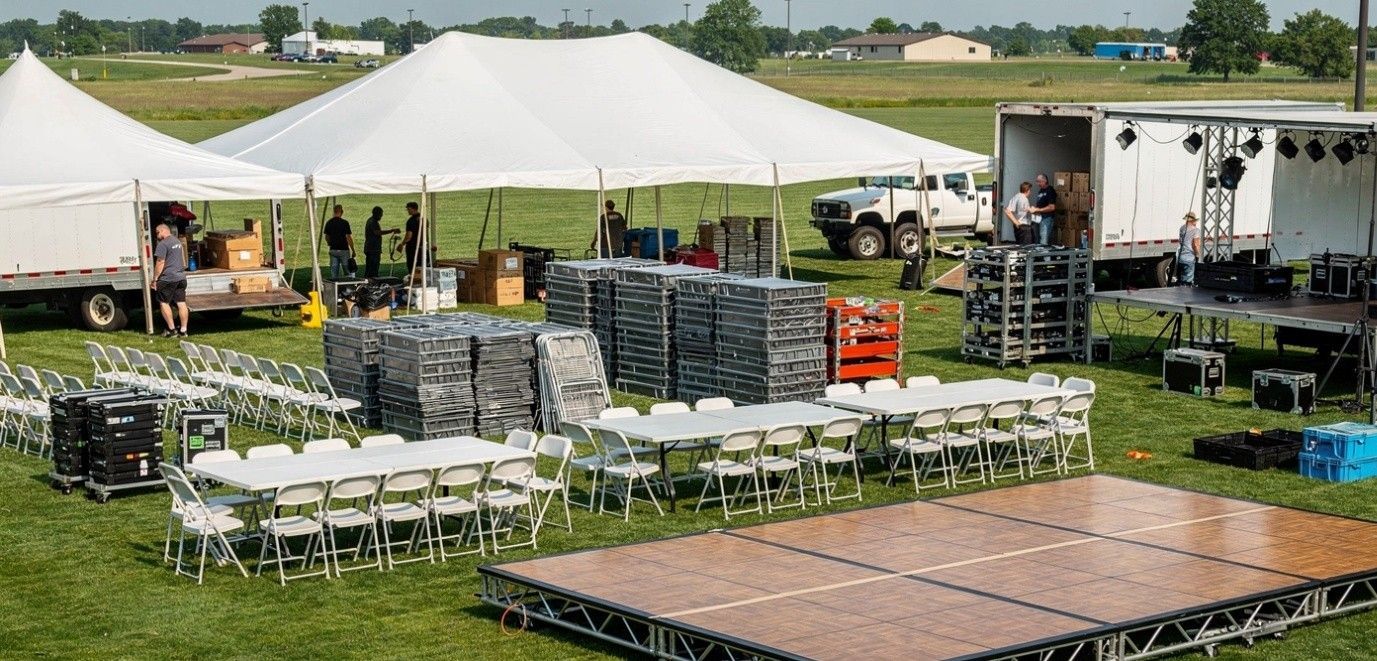 A large black inflatable tent is sitting on top of a lush green field.