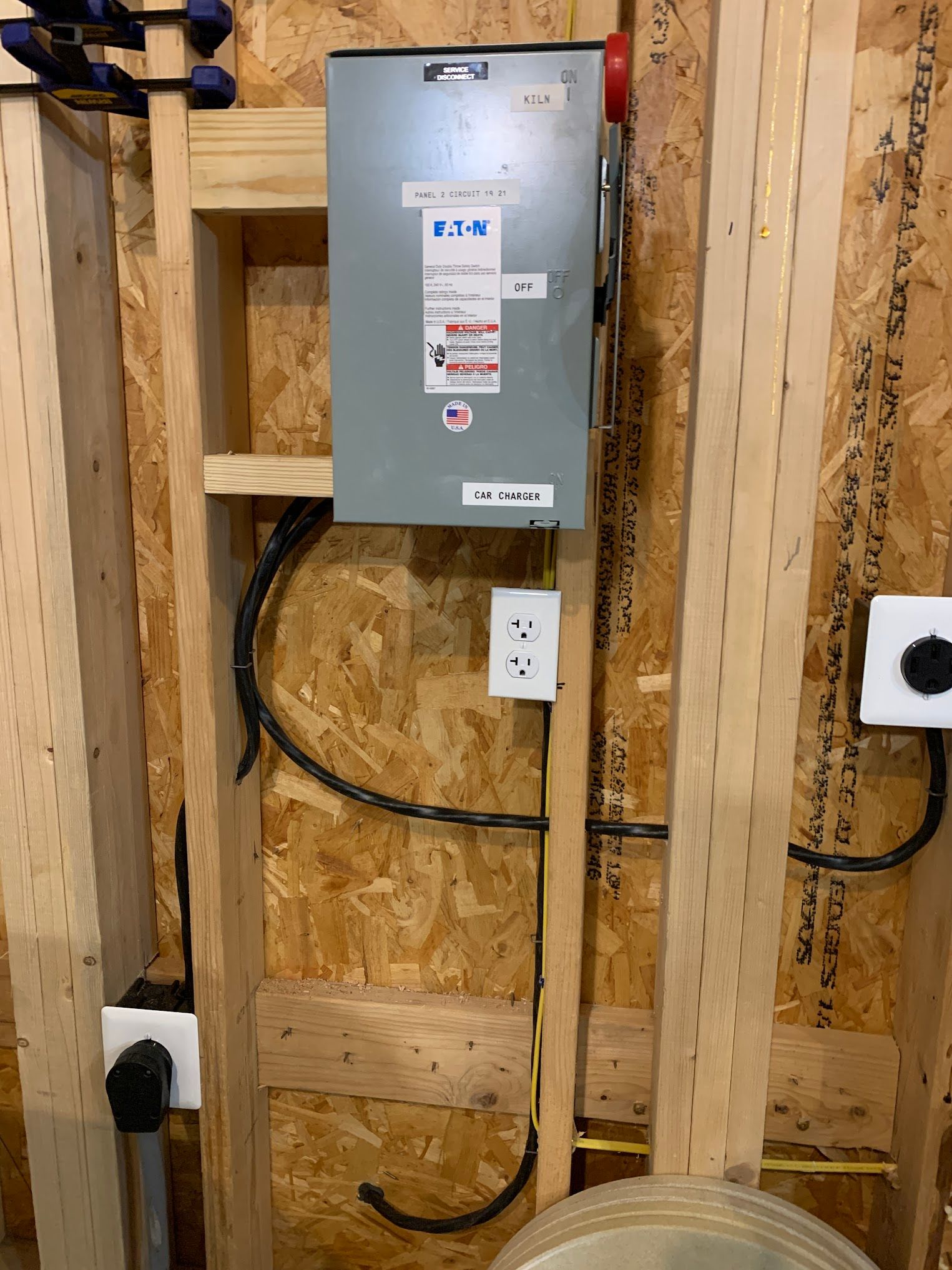 A box with a label on it is hanging on a wooden wall.