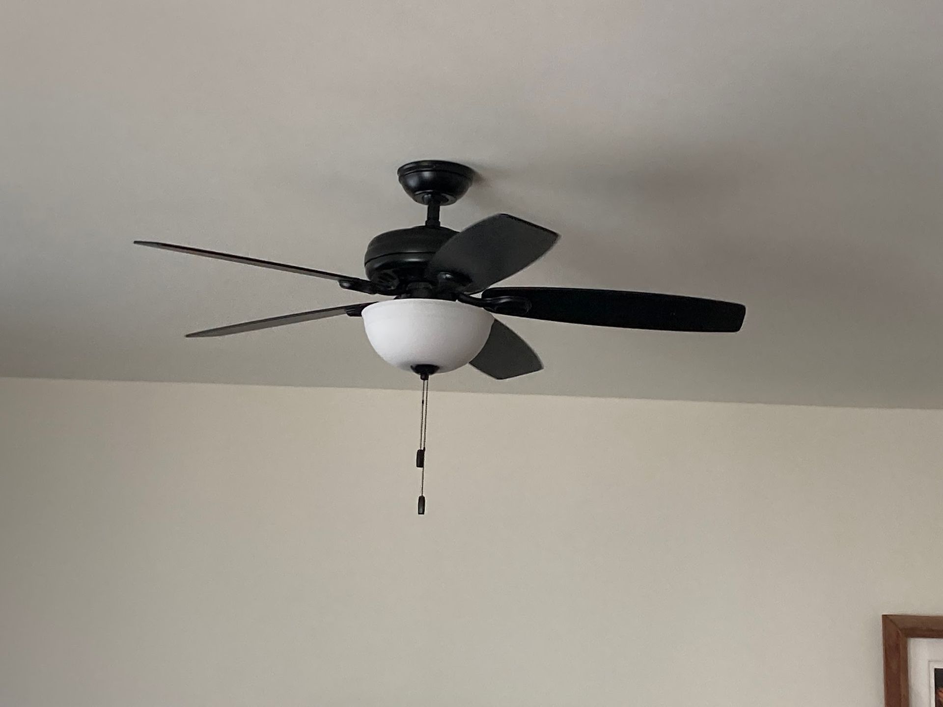 A ceiling fan with a light attached to it is hanging from the ceiling in a room.