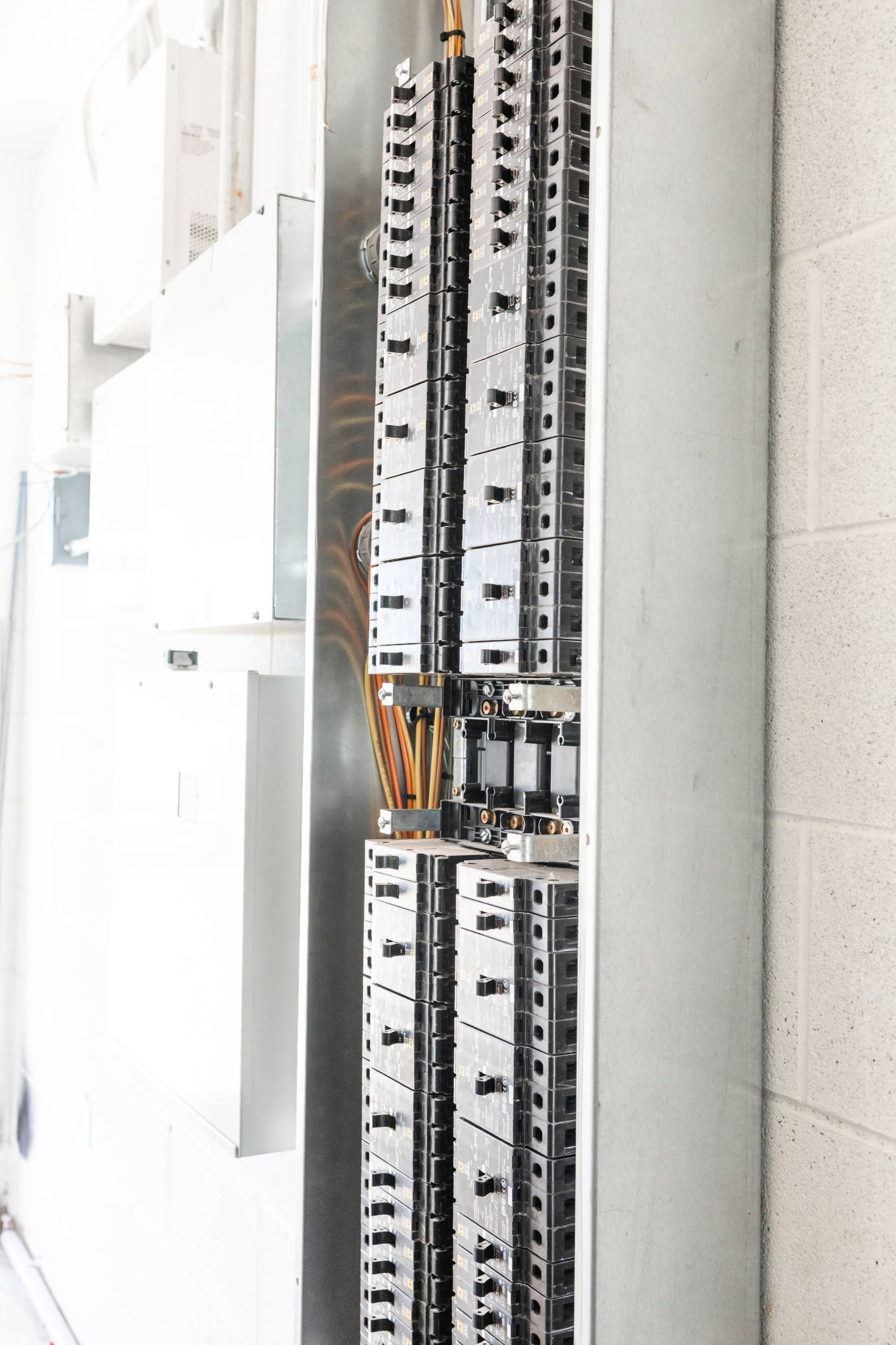 Open electrical panel with wires and circuit breakers.