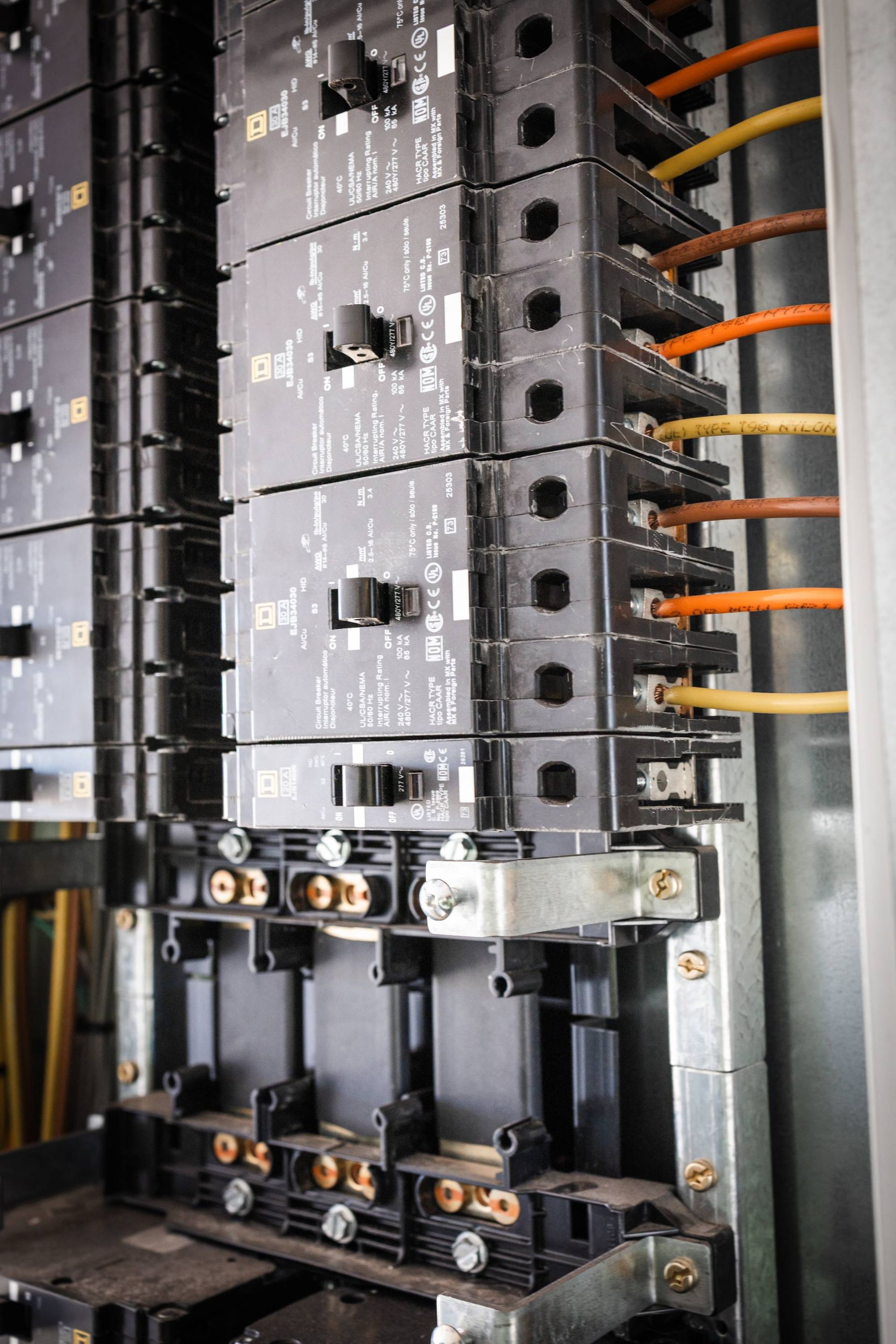 Electrical panel with multiple stacked circuit breakers and wiring.