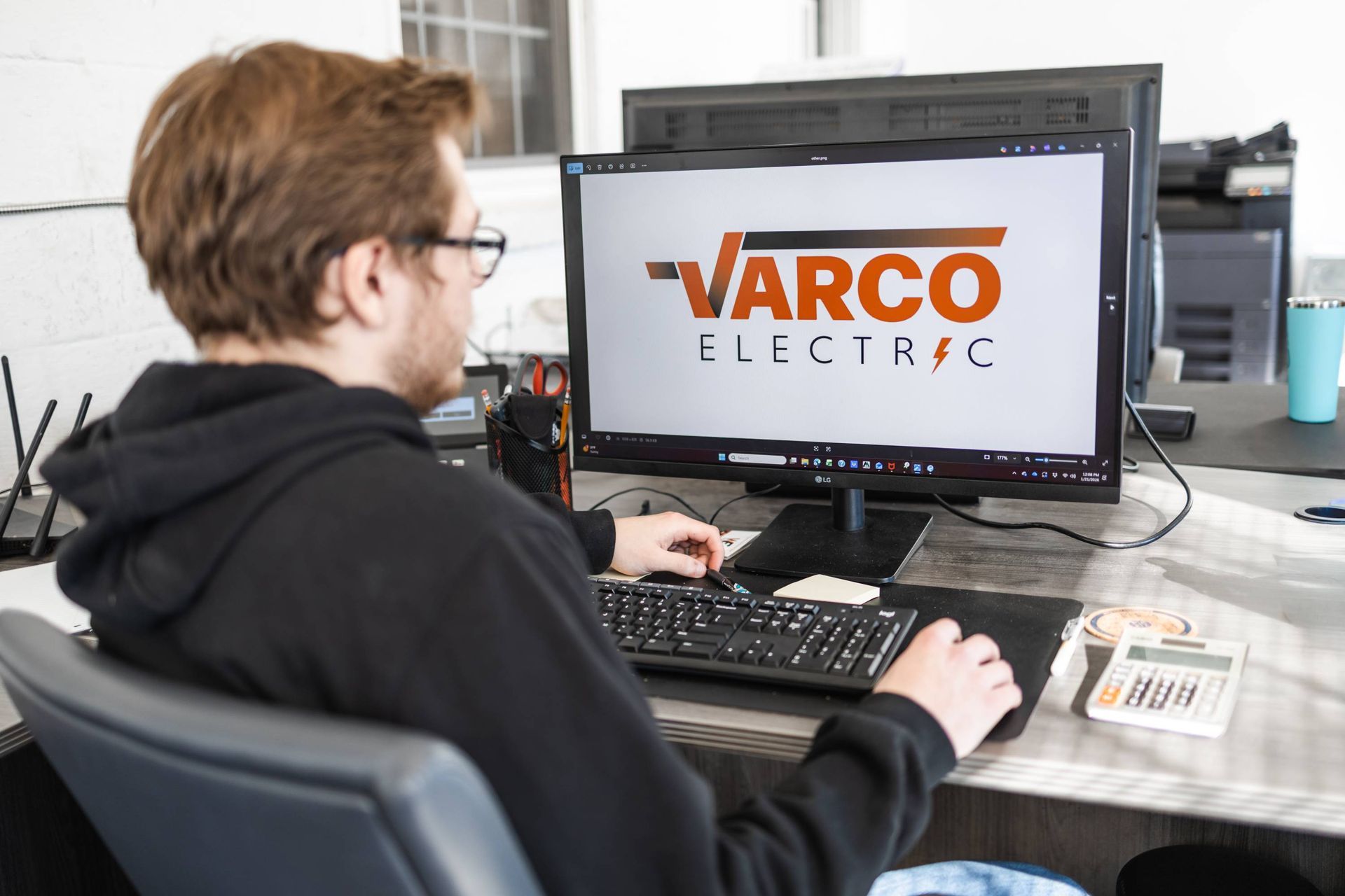 Person working at a desk with a computer displaying the 