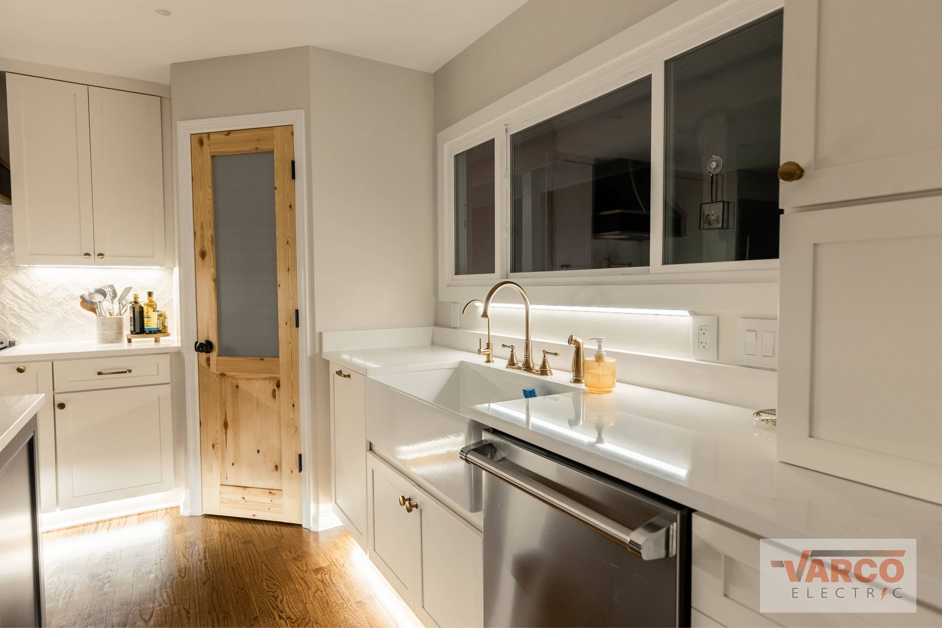 Bright, white kitchen with under-cabinet and recessed lighting. 