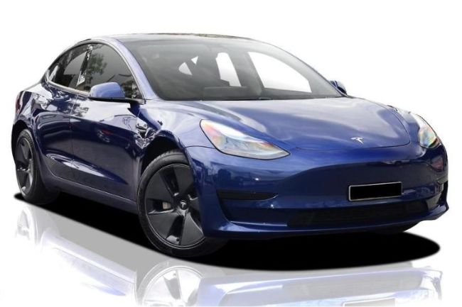 A blue tesla model 3 is sitting on a white surface.