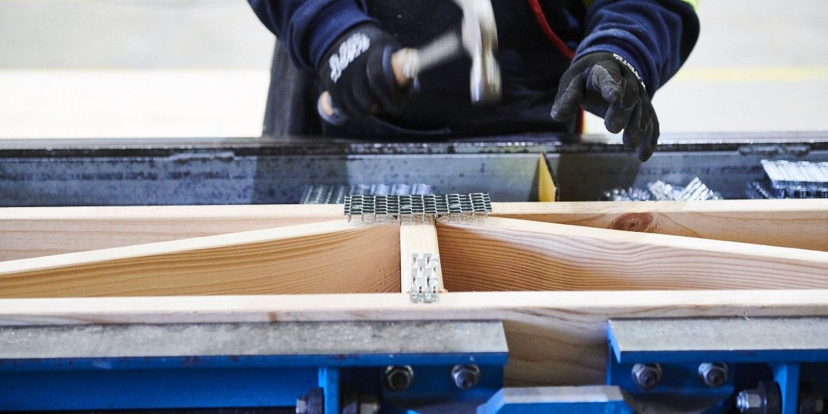 A man is working on a piece of wood with a hammer.