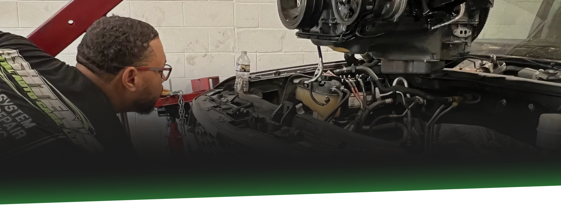 Mechanic inspecting a car engine in a garage. | Ashten's Total Auto Care