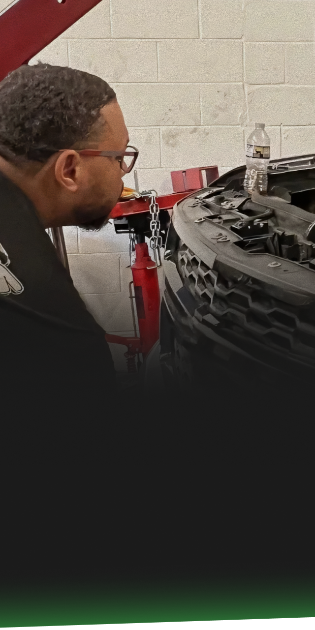 Mechanic inspecting a car engine in a garage. | Ashten's Total Auto Care