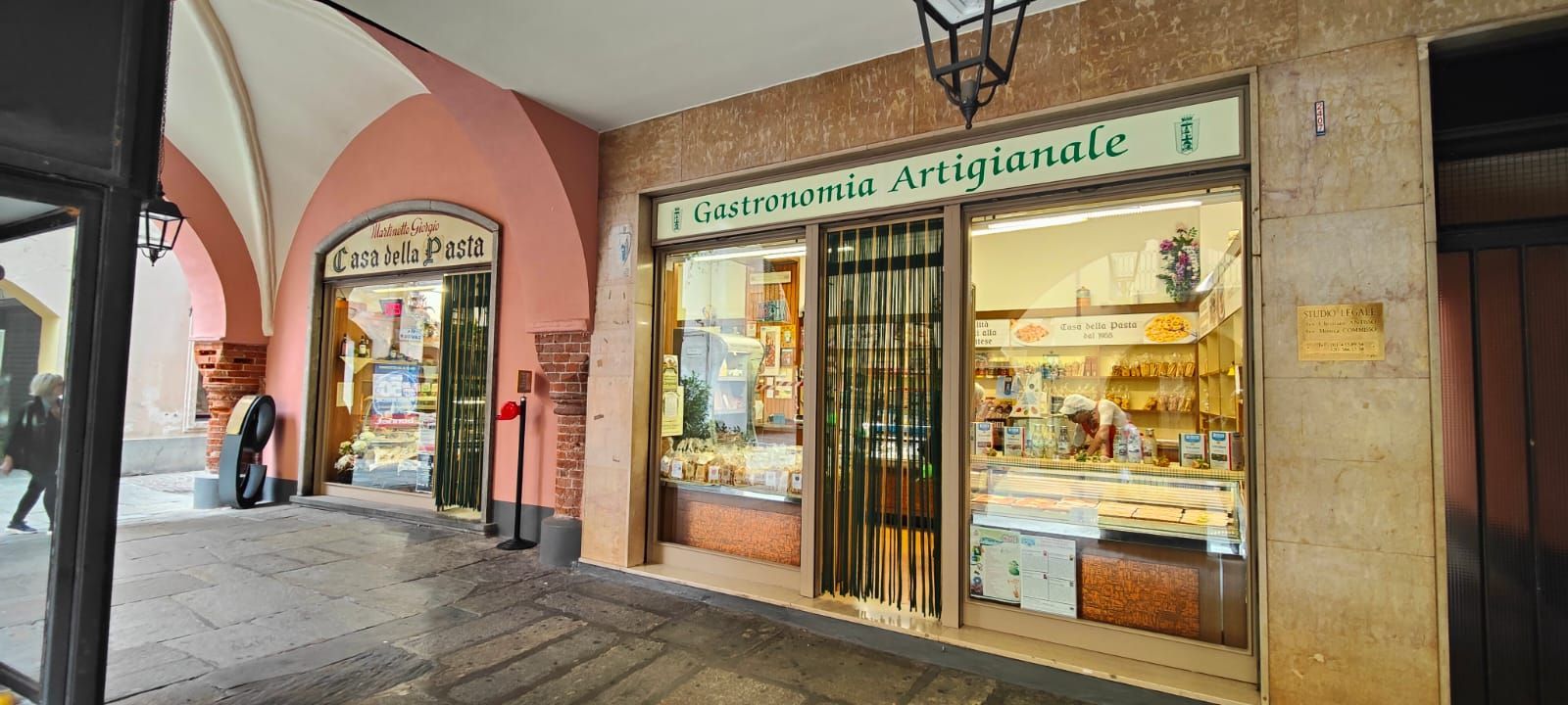 Una facciata di un negozio con una recinzione e degli archi in una città.