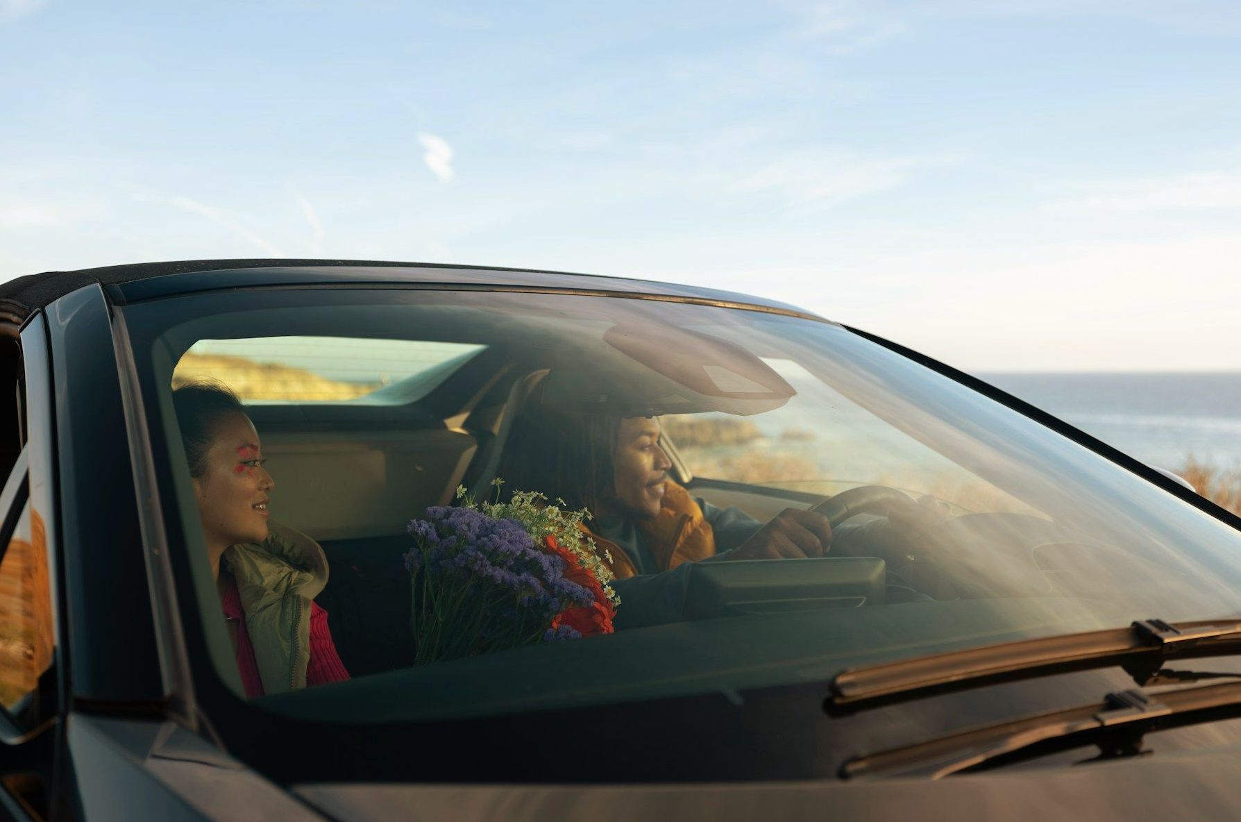 A woman is driving a car with a child in the back seat.