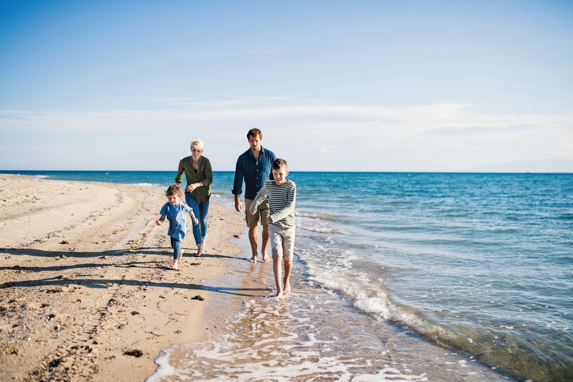A family is walking along the beach.