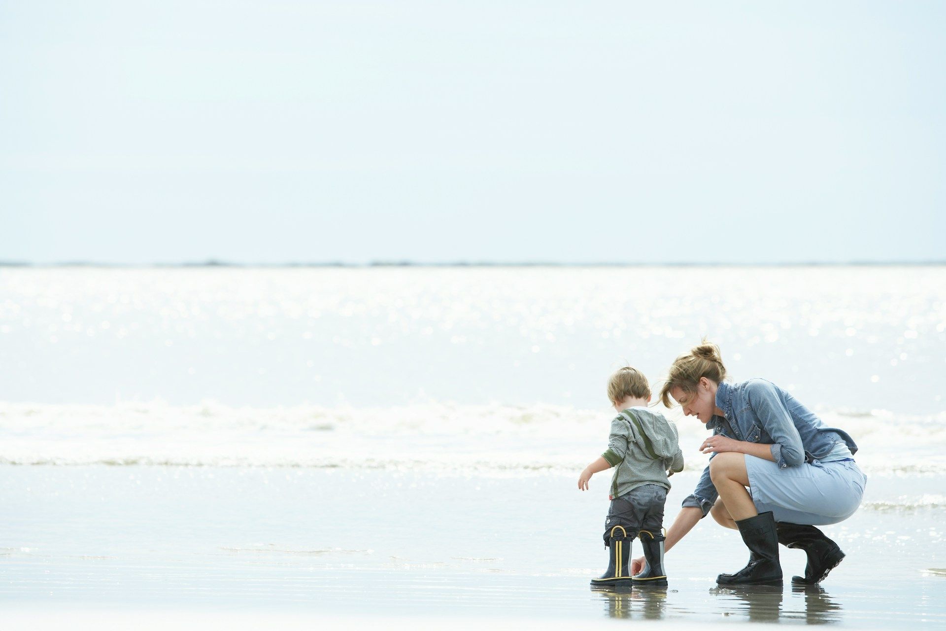 A woman and a child are playing on the beach.