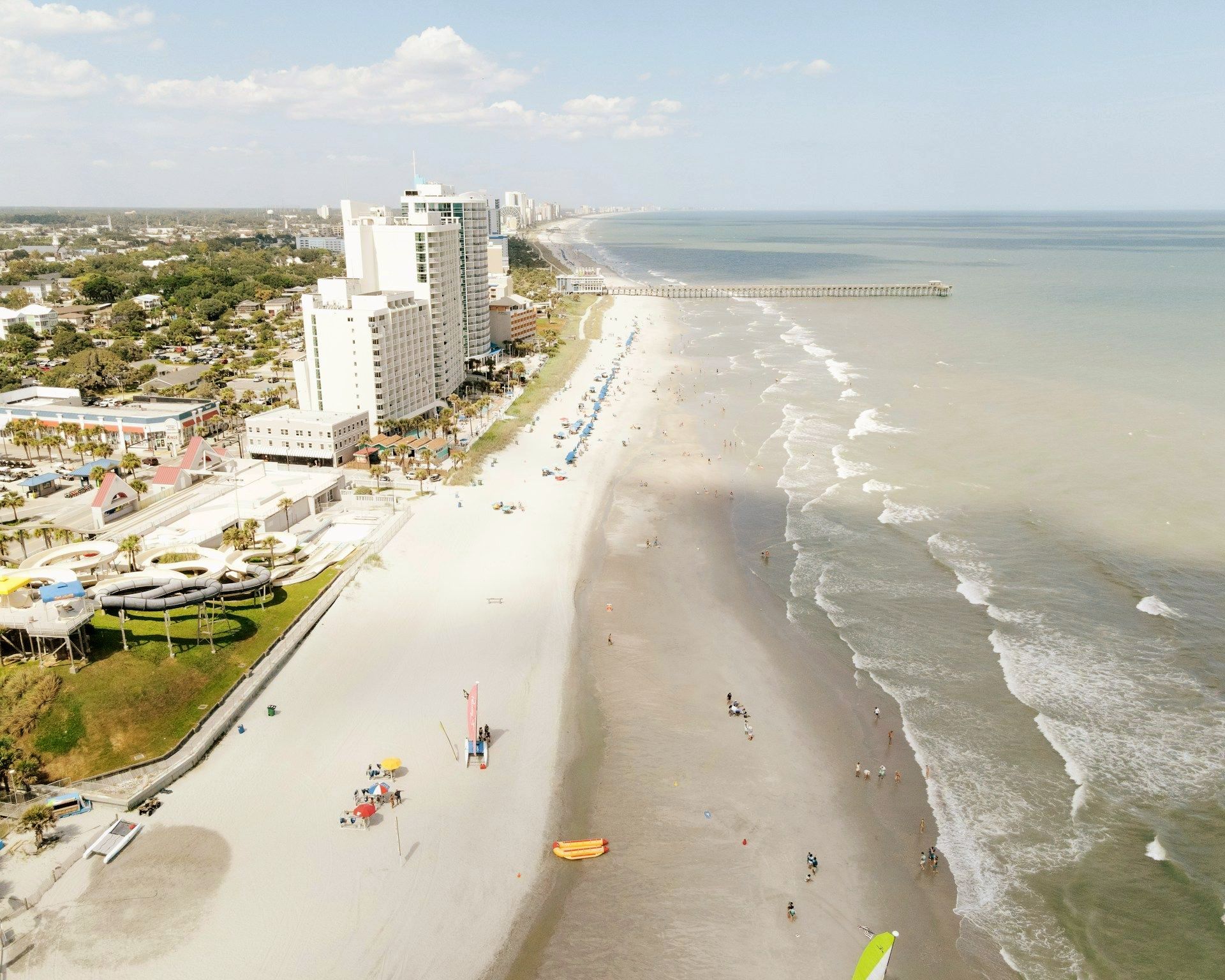An aerial view of a beach with buildings in the background