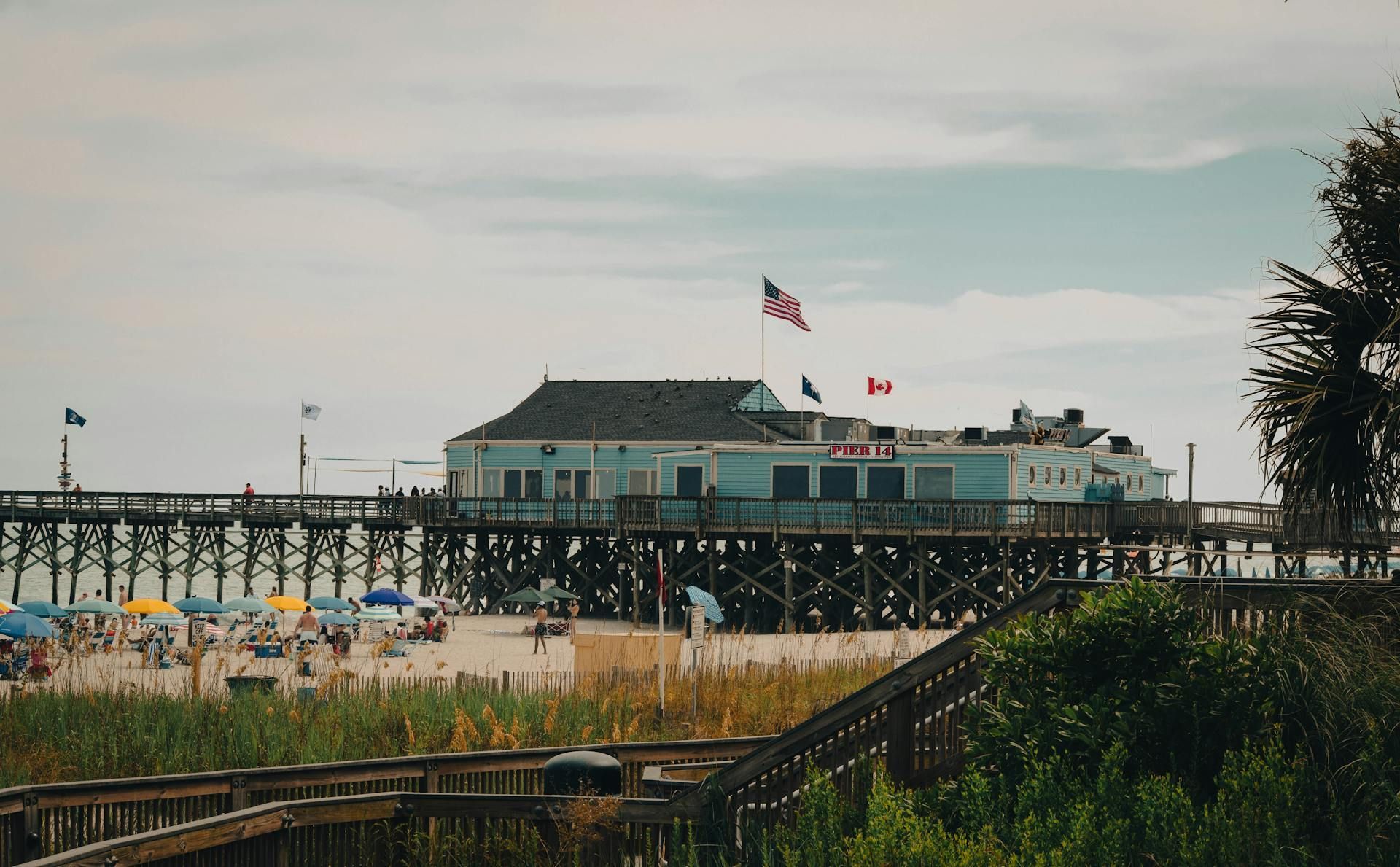 A pier with a building on top of it and a flag on top of it.