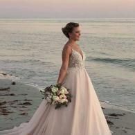 bride on beach holding bouquet