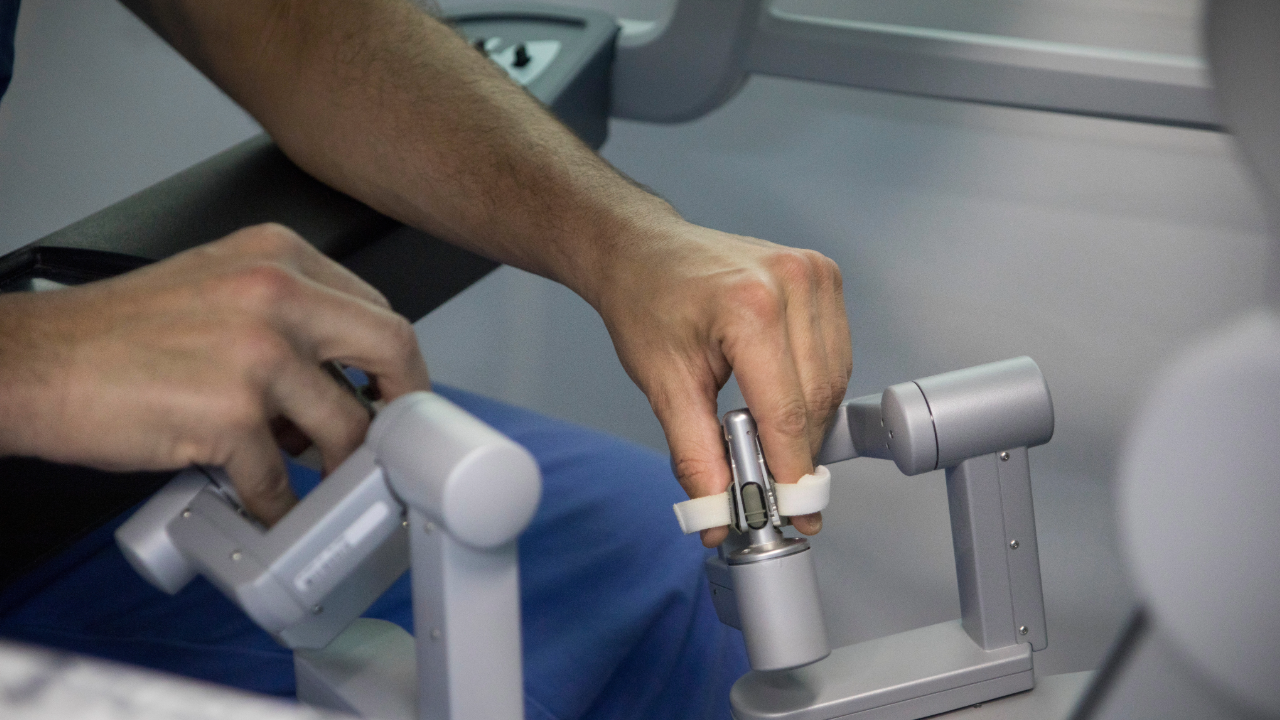 A person is operating a robotic arm in a hospital.