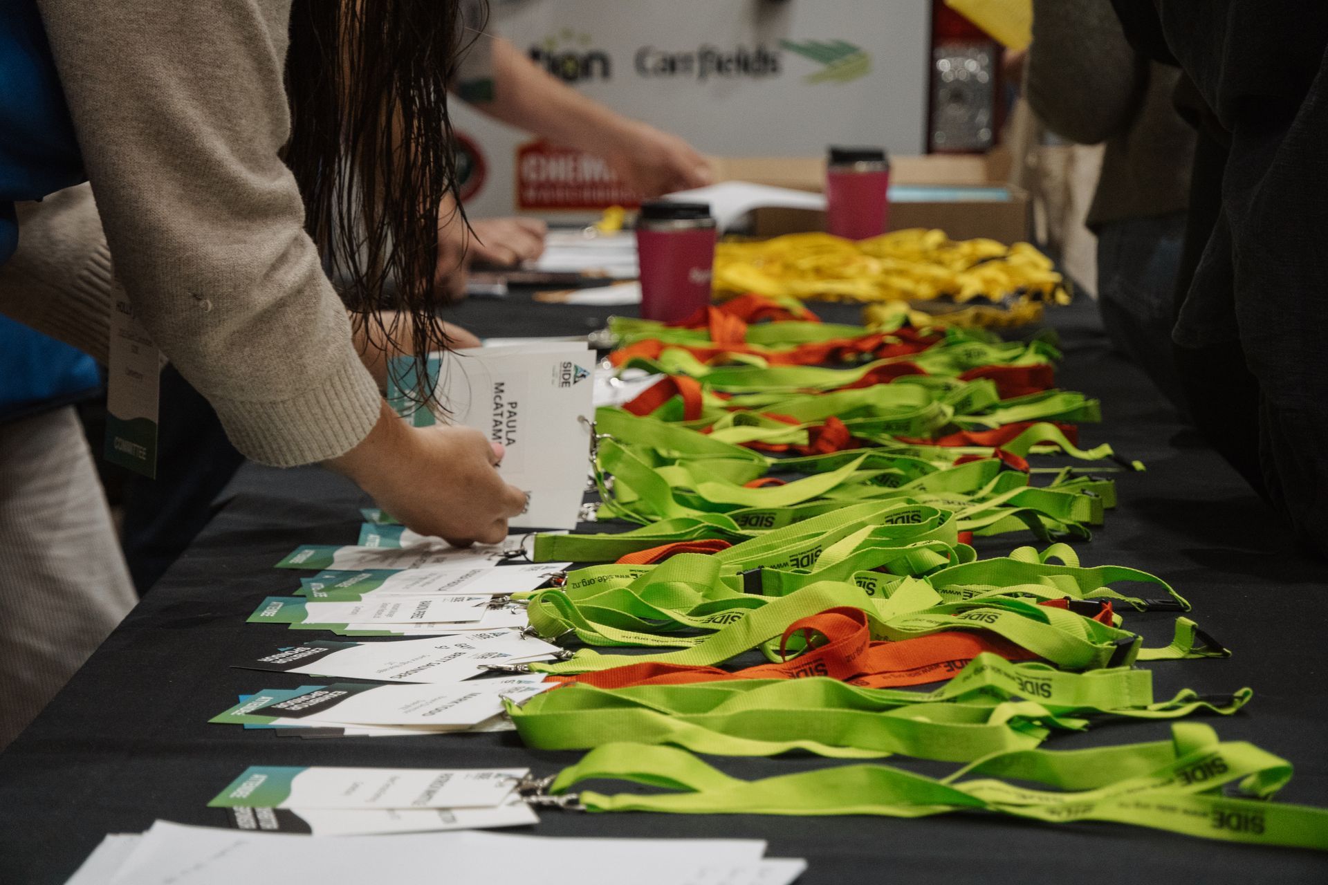 People at a table with name badges and green and orange ribbons.