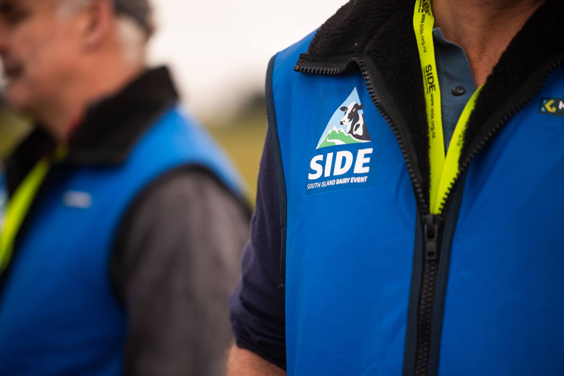 Two people wearing blue vests with 