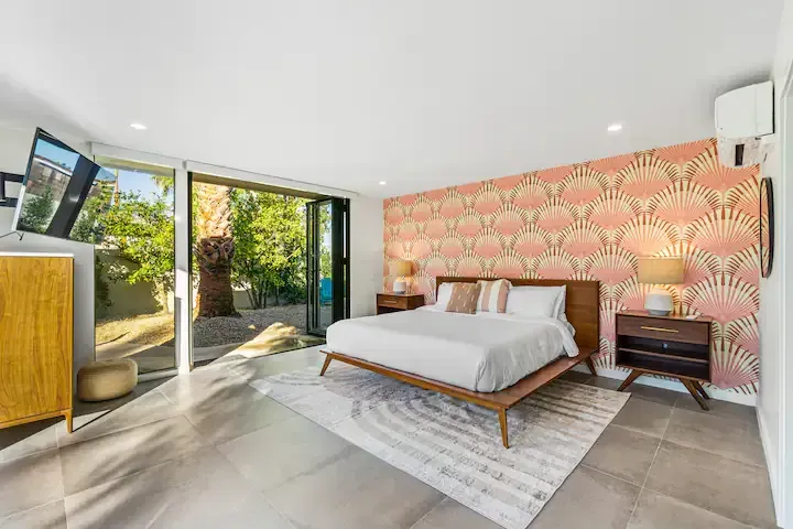 A bedroom with a king size bed , nightstands , and a television.