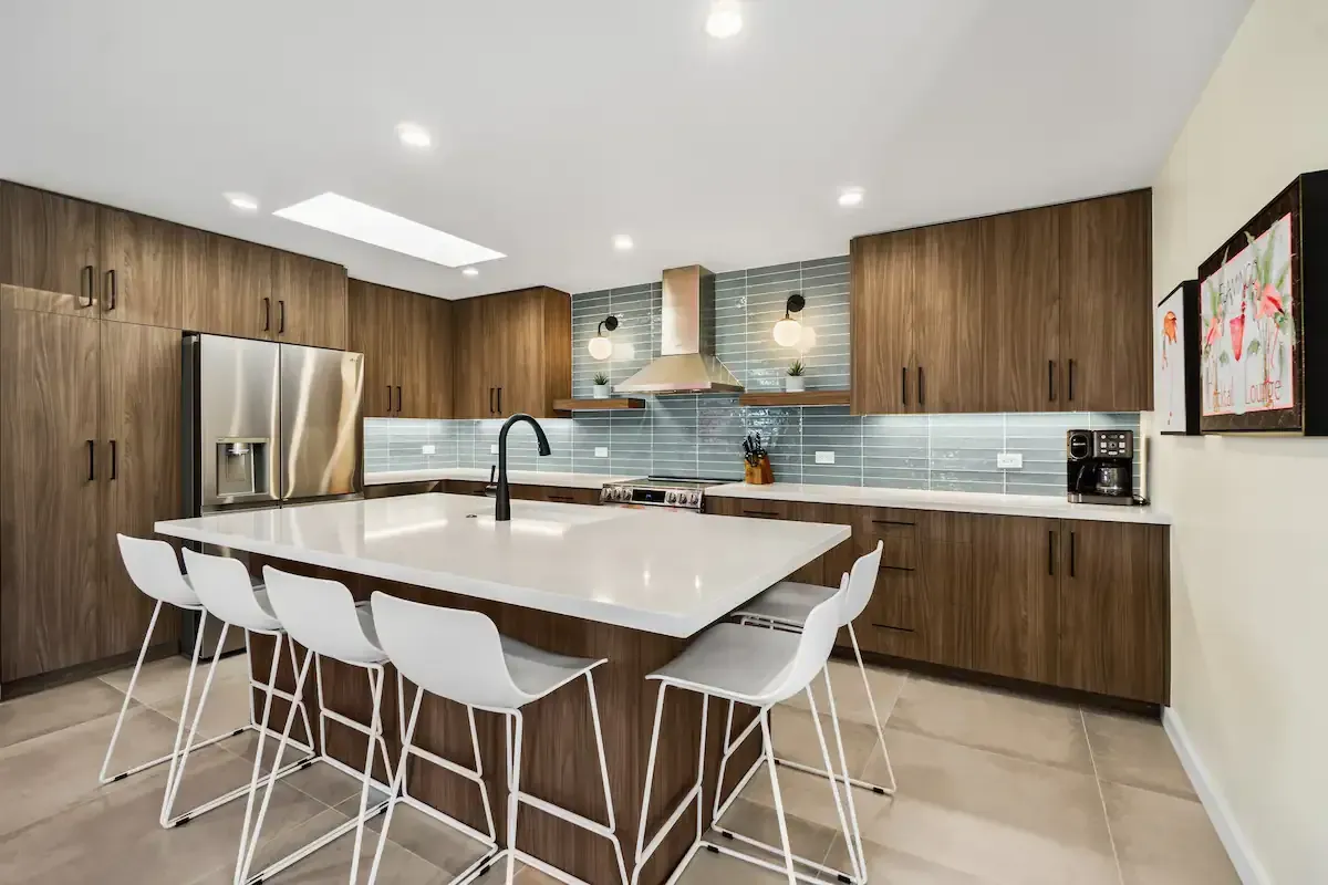 A kitchen with stainless steel appliances , wooden cabinets , and a large island.