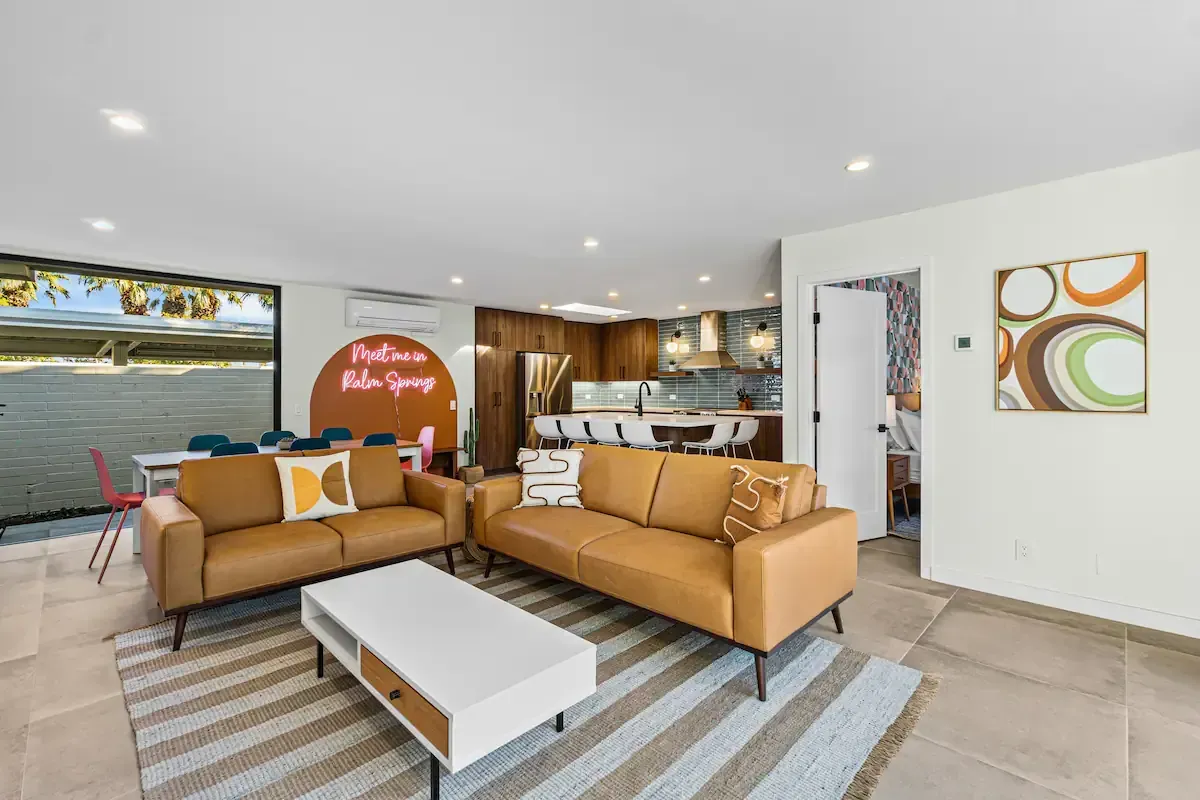 A living room with two couches , a coffee table , and a rug.