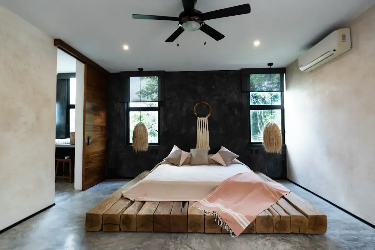 A bedroom with a bed and a ceiling fan