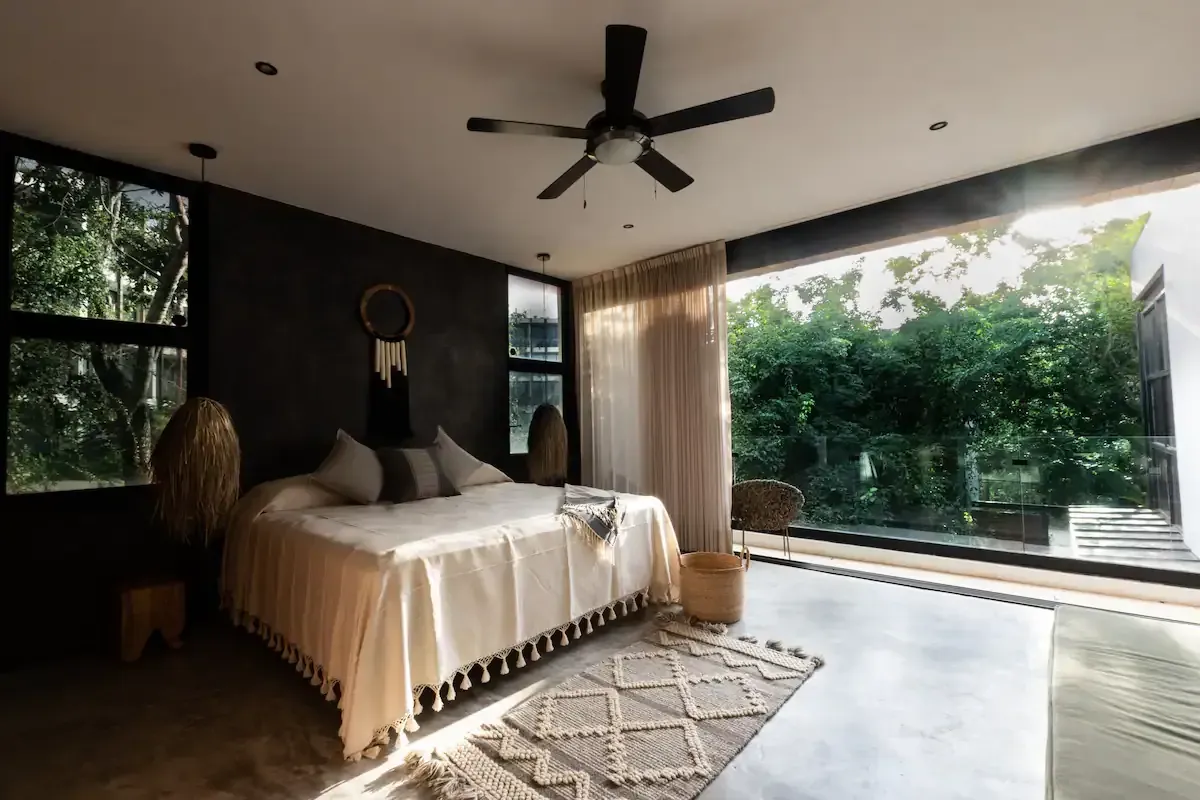 A bedroom with a large bed and a ceiling fan.