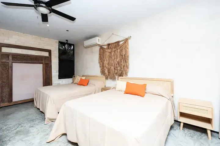 A hotel room with two beds and a ceiling fan.