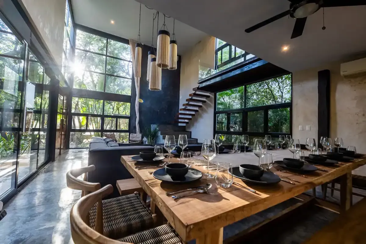 A dining room with a long wooden table and chairs.