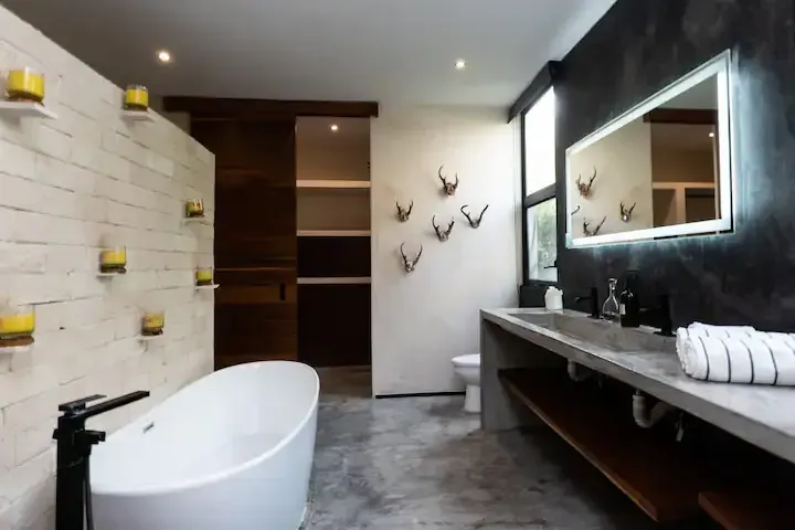 A bathroom with a bathtub , sink and mirror