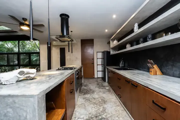 A kitchen with a skull on the counter and a ceiling fan.