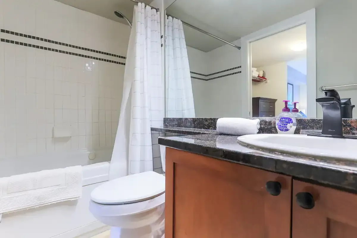 A bathroom with a toilet , sink and bathtub.