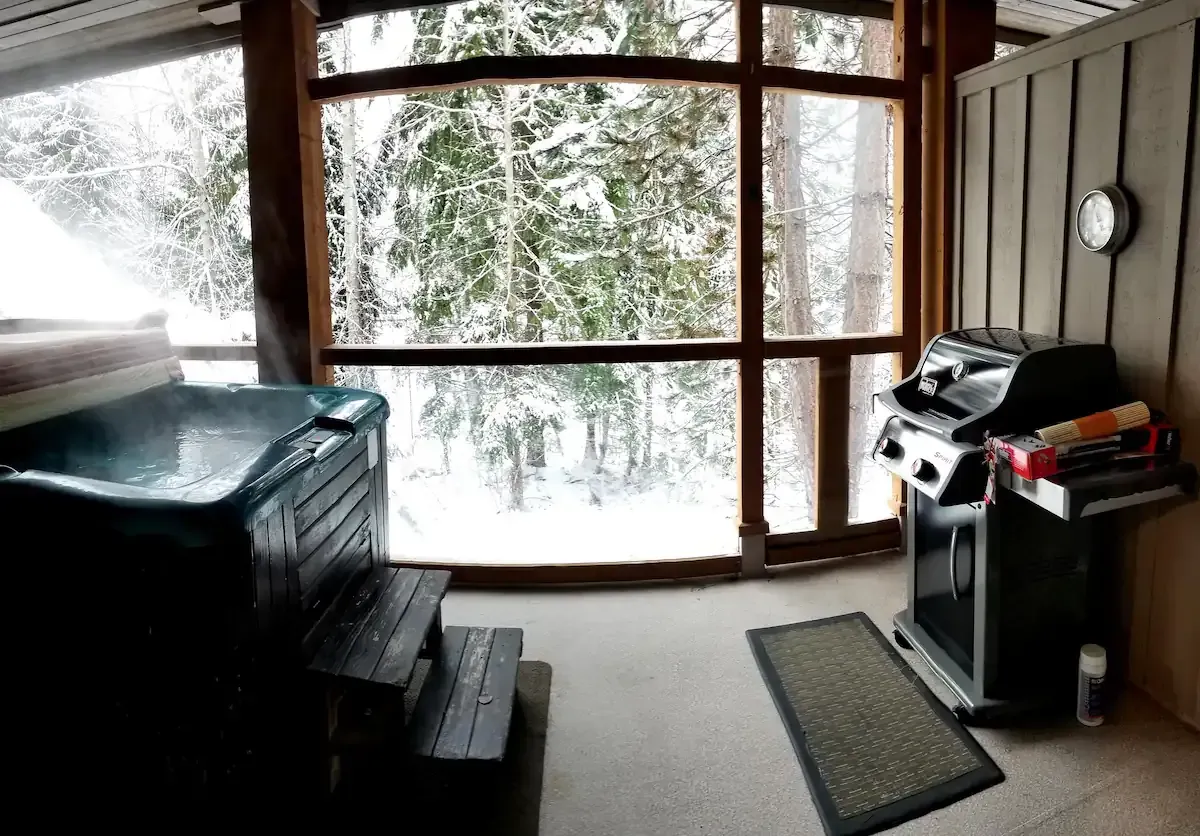 A patio with a hot tub and a grill