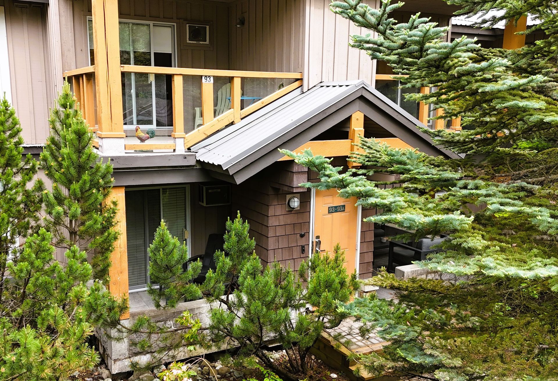 A house with a balcony and trees in front of it